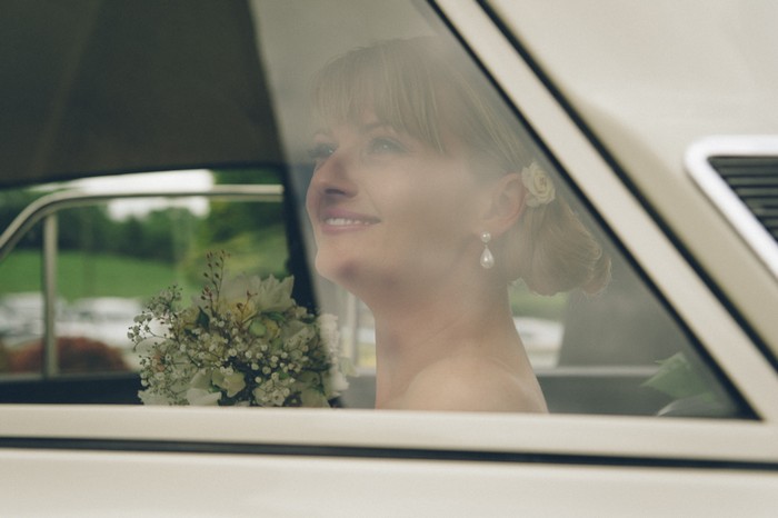 bride in wedding car through window